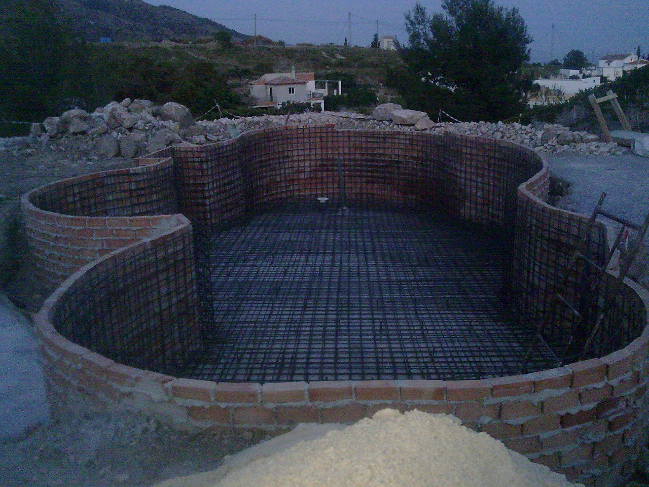 Montaje de armadura de ferralla en losa de hormigón para piscina enterrada en Viñuela, Málaga